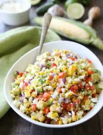 Corn Salad with Queso Fresco is loaded with grilled corn, crisp onions and peppers, and creamy avocado, all topped with a homemade cilantro lime vinaigrette and generous helping of delicious queso fresco. A great side dish for your summer barbecue.