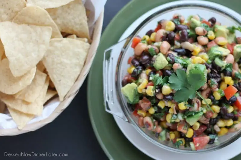 Cowboy Caviar is a chunky salsa-type dip with beans, avocado, tomatoes, corn and a zesty dressing. Great for picnics, potlucks, parties, or a game day snack!
