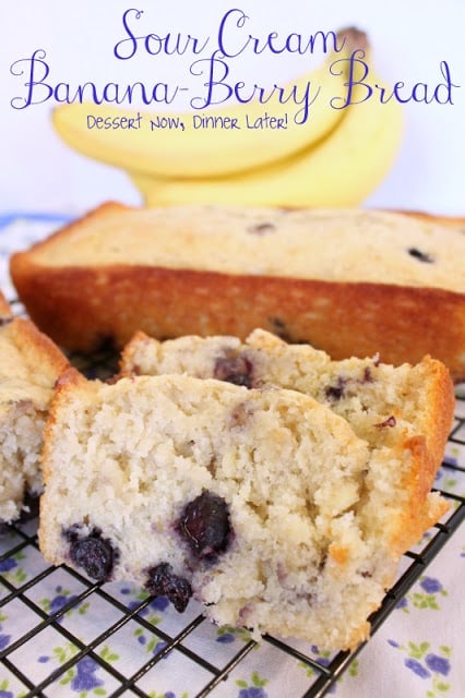 Slices of sour cream banana blueberry bread on a wire rack.