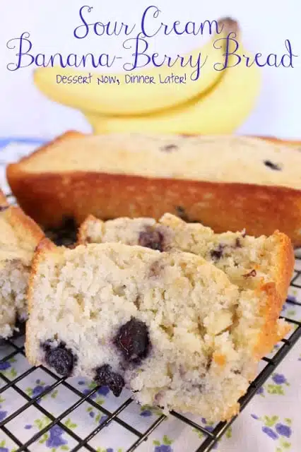 Slices of sour cream banana blueberry bread on a wire rack.