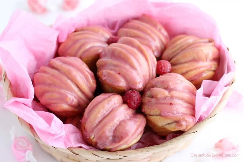 Layered raspberry butterflake rolls in a basket with raspberry glaze. 