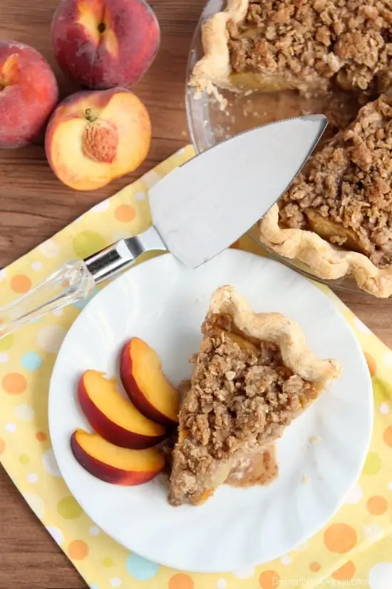 A slice of Peach Pie with streusel topping on a plate.
