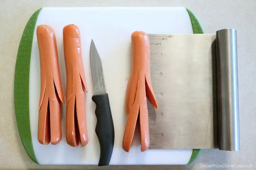 Hot dogs with arms and legs cut with a knife.