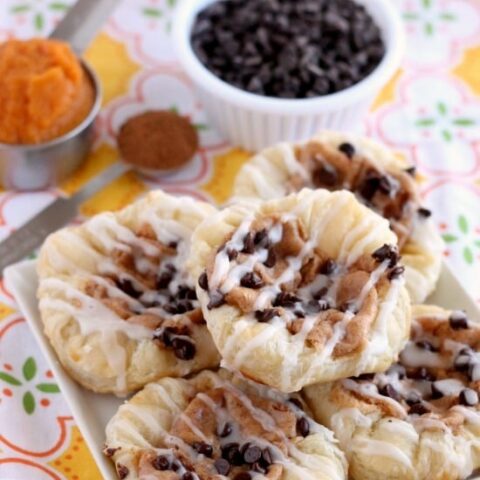 Pumpkin Chocolate Chip Pastries are made with frozen puff pastry dough, a spiced pumpkin cream cheese, and mini chocolate chips! They are especially delicious warm from the oven with a powdered sugar glaze! From DessertNowDinnerLater.com