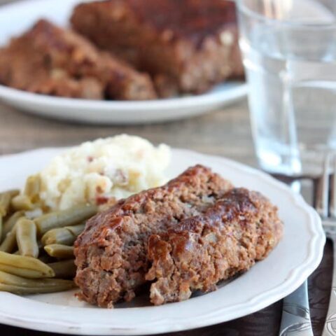 Steak Lovers' Meatloaf - A1 steak sauce, garlic, and onions on the inside, with more steak sauce slathered on the outside, makes this meatloaf both moist and delicious! From DessertNowDinnerLater.com