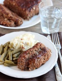 Steak Lovers' Meatloaf - A1 steak sauce, garlic, and onions on the inside, with more steak sauce slathered on the outside, makes this meatloaf both moist and delicious! From DessertNowDinnerLater.com