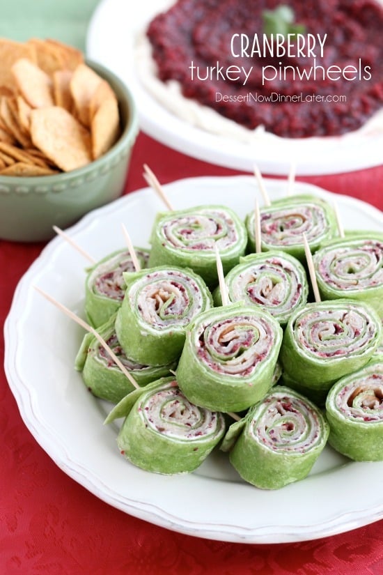 Cranberry Turkey Pinwheels have layers of cream cheese, spicy-sweet cranberry salsa, and thinly sliced turkey all rolled up in a spinach tortilla for a delicious party appetizer! From DessertNowDinnerLater.com