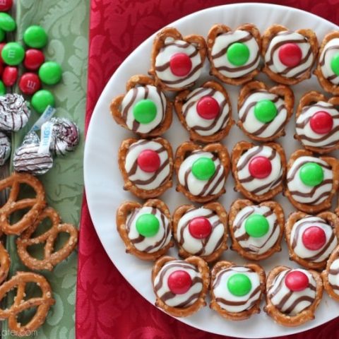 These festive Christmas Pretzel Hugs are melted just enough to press an M&M on the top. Let the chocolate set back up and then package them for neighbor gifts, or place them on a plate for the perfect salty-sweet treat! From DessertNowDinnerLater.com