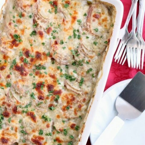 Tuscan Scalloped Potatoes - Thinly sliced potatoes covered in a simple Tuscan seasoned sauce, topped with Parmesan and Mozzarella cheeses, then baked and browned to perfection! From DessertNowDinnerLater.com
