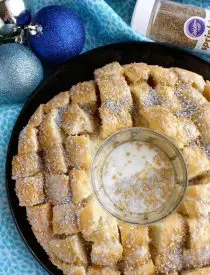 This New Year’s Party Loaf is filled with honey butter, topped with a powdered sugar glaze, and made to sparkle with edible silver and gold pearlized sugar sprinkles.