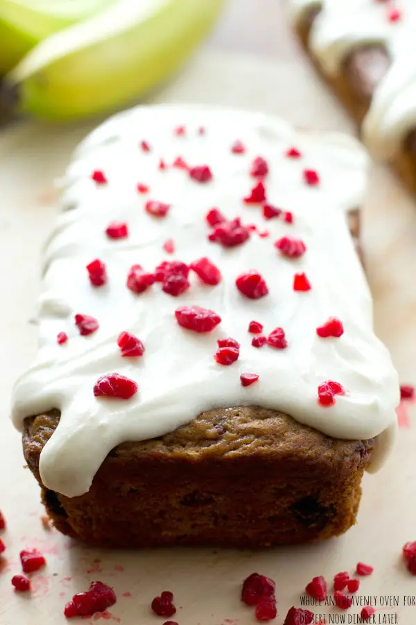 This super-soft and moist banana bread is exploding with a double-delight of juicy berries and perfectly covered in a tangy cream cheese icing. | dessertnowdinnerlater.com