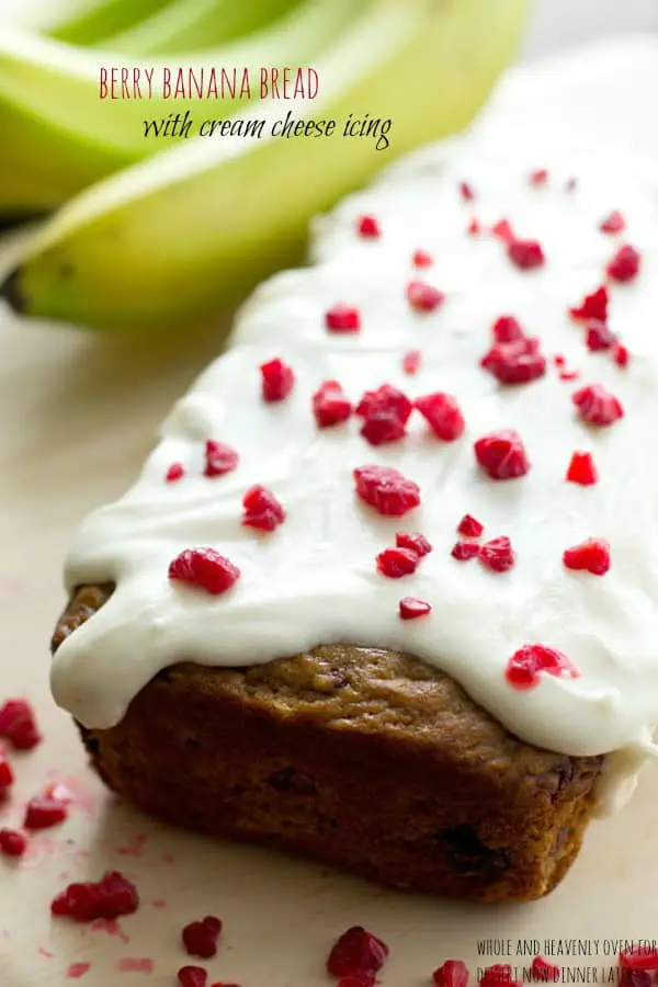 This super-soft and moist banana bread is exploding with a double-delight of juicy berries and perfectly covered in a tangy cream cheese icing. | dessertnowdinnerlater.com