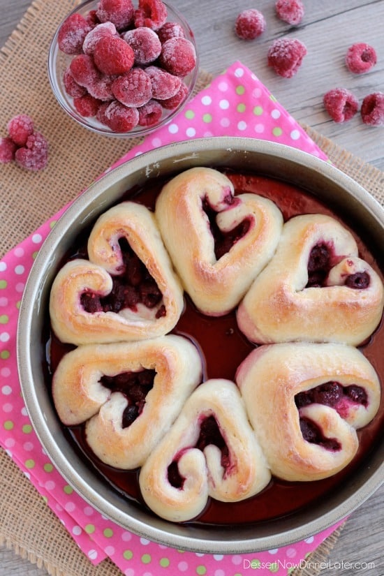 Heart shaped raspberry rolls in a round cake pan.