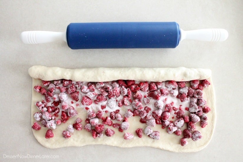 Rolling top edge of the dough over the berries, and stopping in the center.
