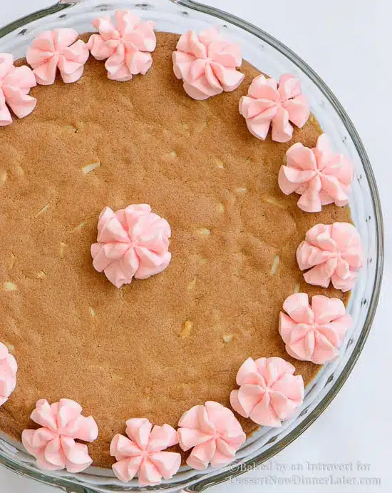 Almond Cherry Cookie Cake - Almond flavored sugar cookie cake with slivered almonds throughout and topped with cherry frosting. The best sugar cookie you will ever have!