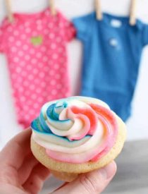 These Gender Reveal Cupcakes have pink, blue, and white swirled frosting on top that hides the secret colored heart in the center of the cupcake revealing the baby's gender when you bite into it! (Step-by-Step Photo Tutorial)
