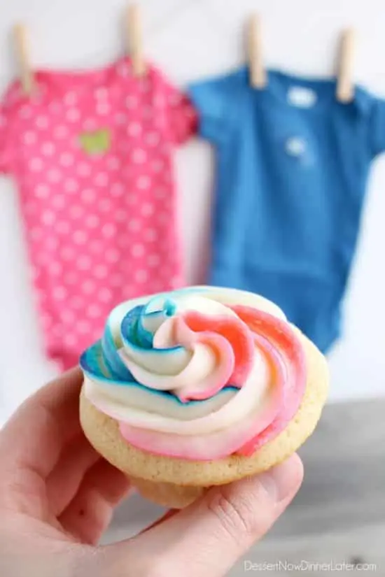 These Gender Reveal Cupcakes have pink, blue, and white swirled frosting on top that hides the secret colored heart in the center of the cupcake revealing the baby's gender when you bite into it! (Step-by-Step Photo Tutorial)