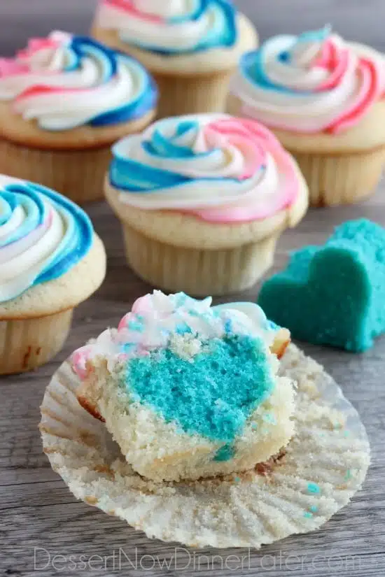 These Gender Reveal Cupcakes have pink, blue, and white swirled frosting on top that hides the secret colored heart in the center of the cupcake revealing the baby's gender when you bite into it! (Step-by-Step Photo Tutorial)