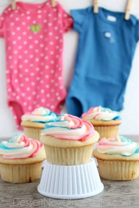 These Gender Reveal Cupcakes have pink, blue, and white swirled frosting on top that hides the secret colored heart in the center of the cupcake revealing the baby's gender when you bite into it! (Step-by-Step Photo Tutorial)