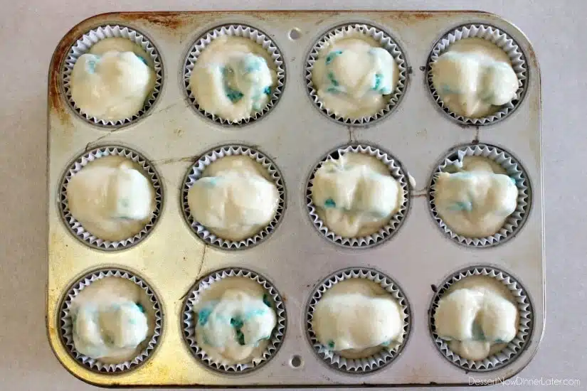 These Gender Reveal Cupcakes have pink, blue, and white swirled frosting on top that hides the secret colored heart in the center of the cupcake revealing the baby's gender when you bite into it! (Step-by-Step Photo Tutorial)