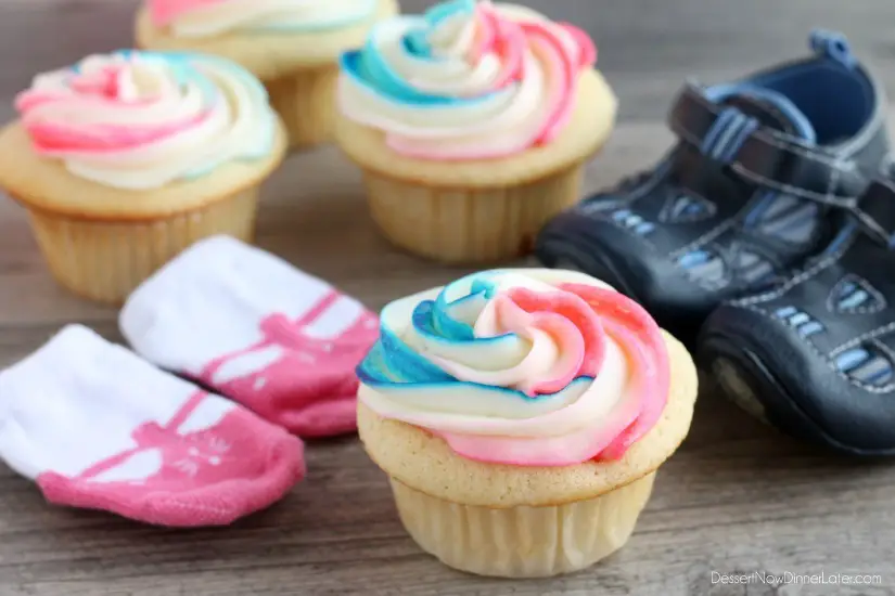 These Gender Reveal Cupcakes have pink, blue, and white swirled frosting on top that hides the secret colored heart in the center of the cupcake revealing the baby's gender when you bite into it! (Step-by-Step Photo Tutorial)