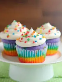 These Rainbow Cupcakes are made with a simple boxed white cake mix, colored, and layered to make a rainbow, with whipped cream cheese frosting on top! (Includes photo tutorial, and tips on baking cupcakes to perfection!)