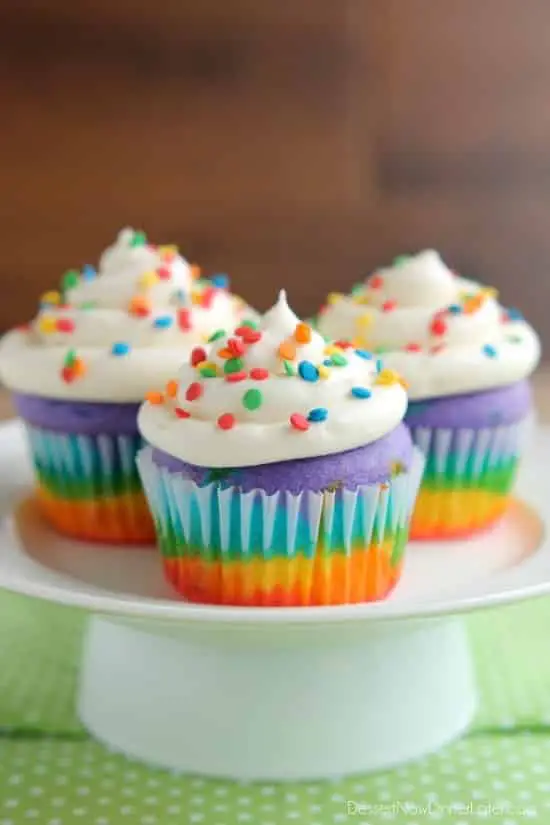 These Rainbow Cupcakes are made with a simple boxed white cake mix, colored, and layered to make a rainbow, with whipped cream cheese frosting on top! (Includes photo tutorial, and tips on baking cupcakes to perfection!)