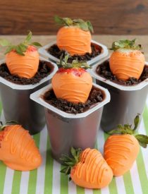 Carrot Easter Pudding Cups - These fun pudding cups are perfect for Spring and Easter with an orange candy dipped strawberry "carrot" in crushed Oreo and chocolate pudding "dirt."