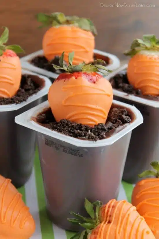 Carrot Easter Pudding Cups - These fun pudding cups are perfect for Spring and Easter with an orange candy dipped strawberry "carrot" in crushed Oreo and chocolate pudding "dirt."