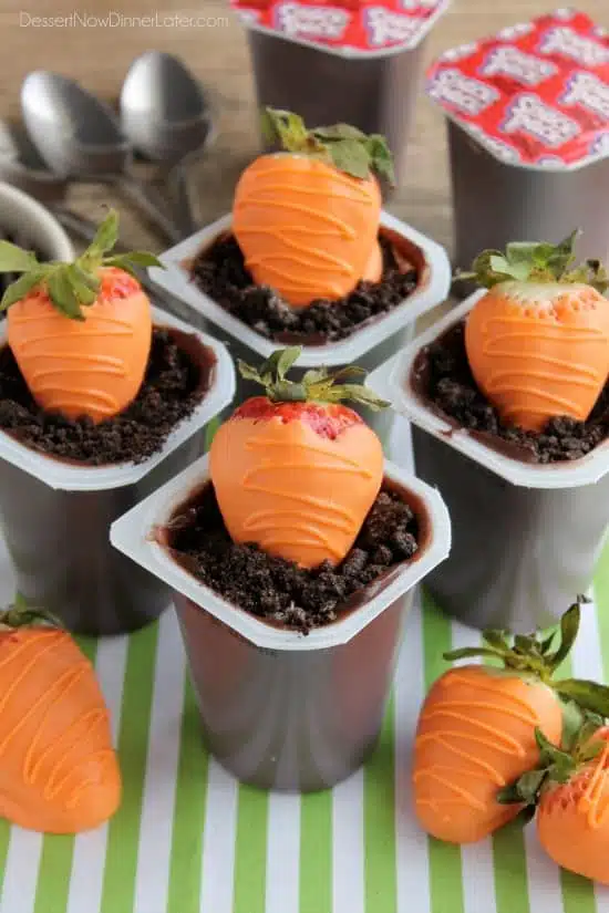 Carrot Easter Pudding Cups - These fun pudding cups are perfect for Spring and Easter with an orange candy dipped strawberry "carrot" in crushed Oreo and chocolate pudding "dirt."