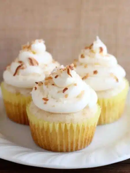 These Pina Colada Cupcakes have crushed pineapple in the cake, and coconut & rum extracts in the frosting, for a frozen drink inspired tropical dessert!
