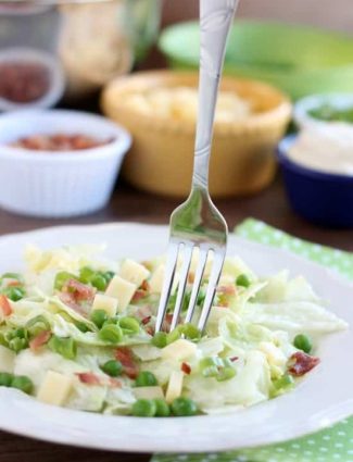 Sarah's Salad from Utah's Lion House restaurant uses crisp iceberg lettuce, peas, bacon, green onions, and swiss cheese tossed in a simple, sweet dressing.