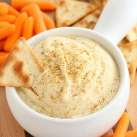 This Easy Garlic Hummus blends up in less than 1 minute for a smooth and creamy homemade hummus that goes perfectly with vegetables and crackers!