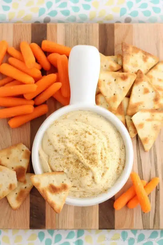 This Easy Garlic Hummus blends up in less than 1 minute for a smooth and creamy homemade hummus that goes perfectly with vegetables and crackers!