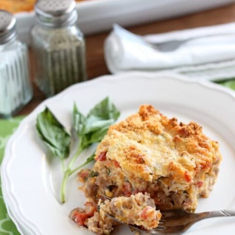 Savory Breakfast Bread Pudding has sausage, tomatoes, eggs, and herbs all in a cheesy bread pudding.