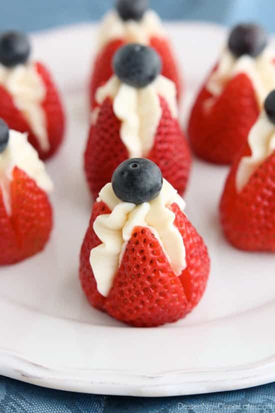 Easy DIY 4th of July Whipped Cream stuffed strawberries with blueberry garnish. Perfect party food and fruit idea for your party.