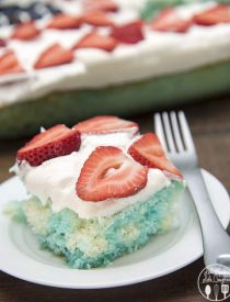 Red strawberries, white cake, and blue jello, come together to create this simple and delicious patriotic Red, White, and Blue Poke Cake perfect for the 4th of July!