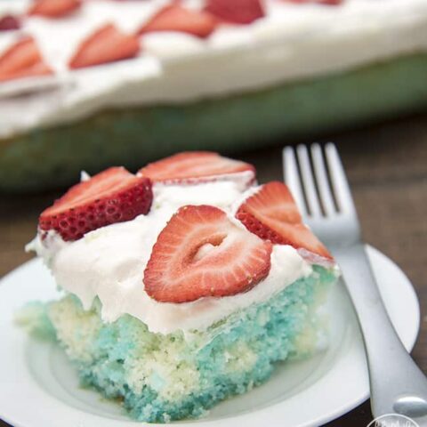 Red strawberries, white cake, and blue jello, come together to create this simple and delicious patriotic Red, White, and Blue Poke Cake perfect for the 4th of July!