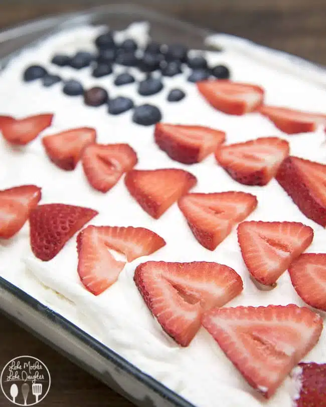 Red strawberries, white cake, and blue jello, come together to create this simple and delicious patriotic Red, White, and Blue Jello Poke Cake perfect for the 4th of July! 