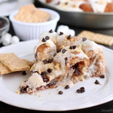 Crushed graham crackers, mini chocolate chips, and mini marshmallows are rolled up in buttery cinnamon sugar rolls to create this S'mores Cinnamon Roll Cake. Top it all off with a marshmallow frosting and extra toppings for a delicious dessert!