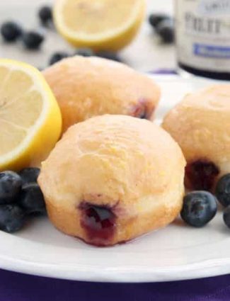 These Jelly Filled Mini Donuts make the perfect breakfast or dessert! Lemon glazed donuts are made easy with refrigerated biscuit dough, and are stuffed with a naturally sweetened blueberry lemon fruit spread.