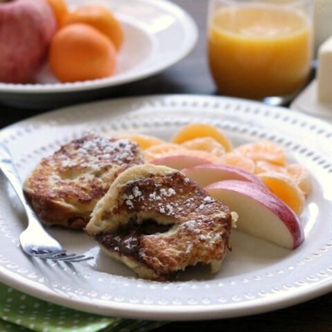 This Chocolate Stuffed French Toast is dipped in a sweet & buttery batter, then grilled until crisp on the outside and melty in the center. A perfect breakfast for the holidays or any time of year!