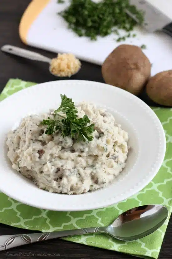 These Slow Cooker Mashed Potatoes are packed with flavor thanks to garlic and herbs, and making them in the slow cooker is the best solution for your Thanksgiving or Christmas dinner!