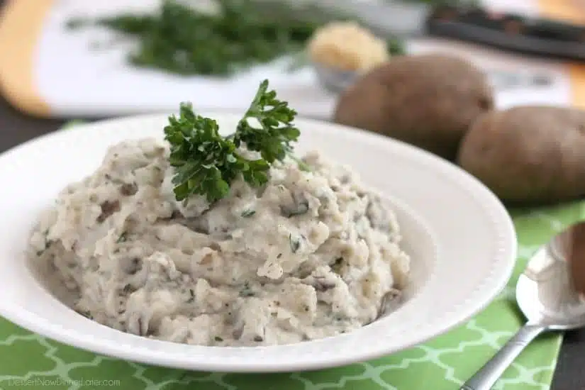 These Slow Cooker Mashed Potatoes are packed with flavor thanks to garlic and herbs, and making them in the slow cooker is the best solution for your Thanksgiving or Christmas dinner!