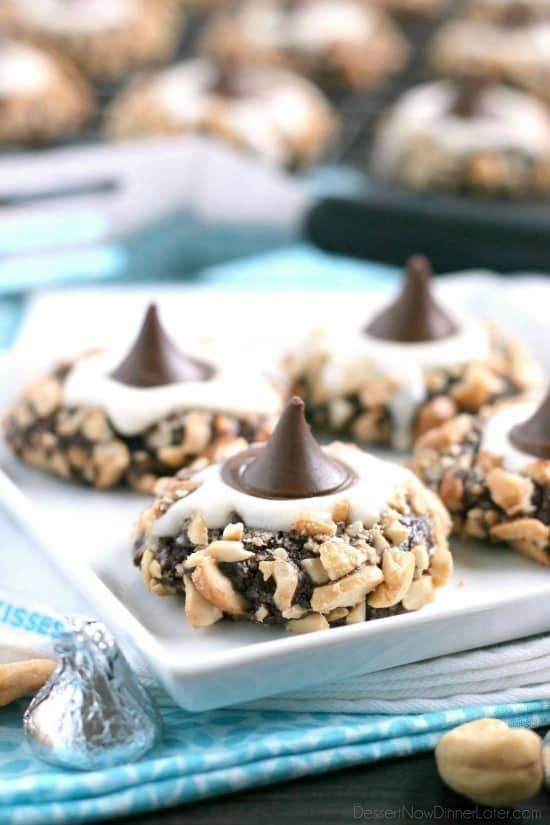Chocolate cookie dough is rolled in nuts and topped with buttercream and chocolate kisses to create these thick and chewy Chocolate Cream Thumbprint Cookies.