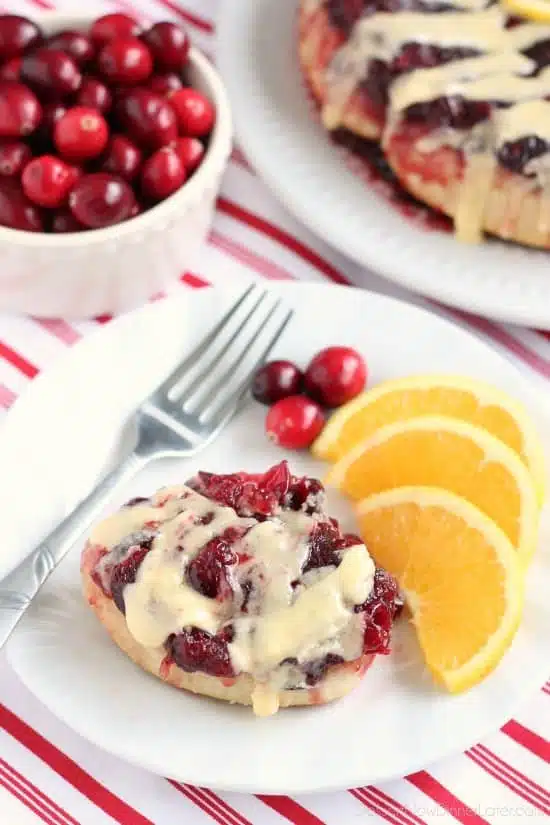 Frozen orange rolls are baked atop fresh cranberry sauce, inverted onto a dish, and drizzled with a delicious orange cream cheese glaze for a Christmas breakfast worth sharing with family and friends.