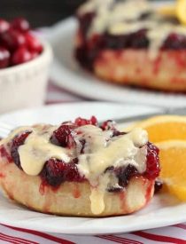 Frozen orange rolls are baked atop fresh cranberry sauce, inverted onto a dish, and drizzled with a delicious orange cream cheese glaze for a Christmas breakfast worth sharing with family and friends.