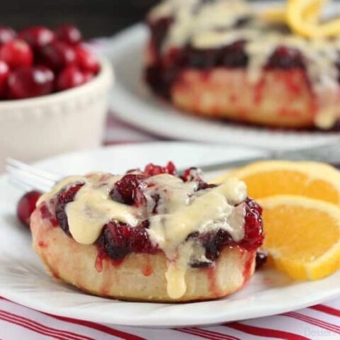 Frozen orange rolls are baked atop fresh cranberry sauce, inverted onto a dish, and drizzled with a delicious orange cream cheese glaze for a Christmas breakfast worth sharing with family and friends.