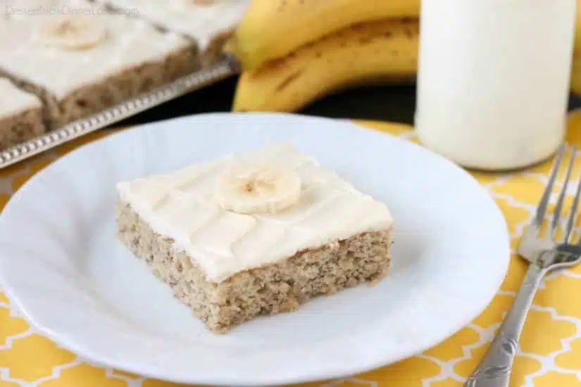 This is the BEST banana cake topped with the BEST cream cheese frosting! Perfect for picnics and potlucks, this banana sheet cake is a crowd pleaser! Everyone asks for the recipe!