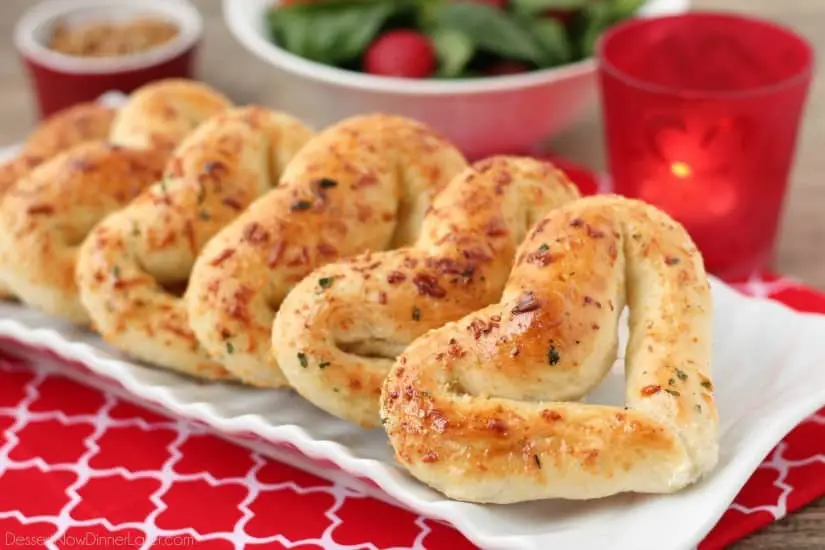 Baked heart shaped breadsticks on a plate.
